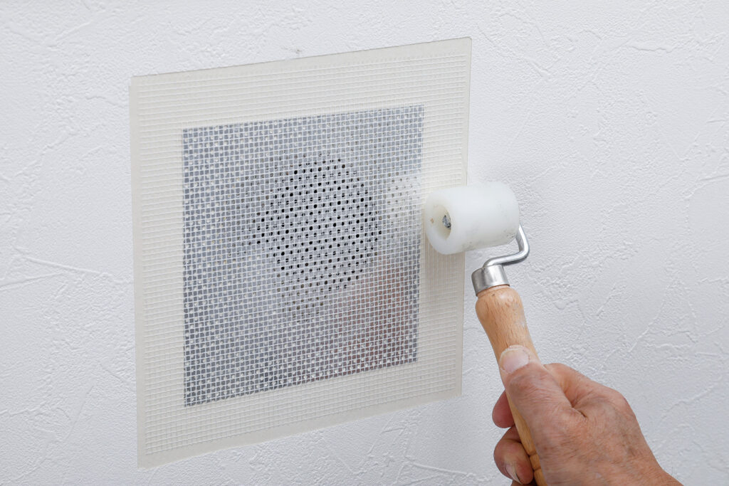 補修シートで壁にあいた大きい穴を補修する