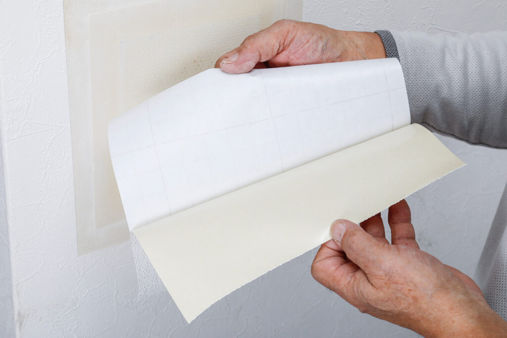 補修シートで壁にあいた大きい穴を補修する